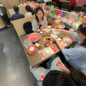 A bustling restaurant interior in Thao Dien, Saigon, featuring multiple tables set for dining. People are seated, interacting, and engaged in meals. T