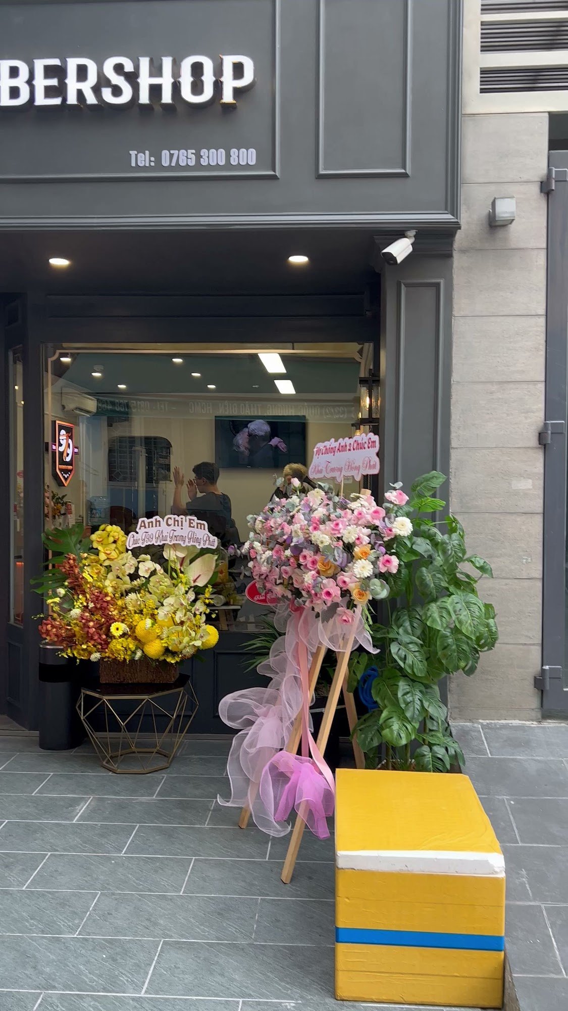 The image shows a storefront of 'BERSHOP' located in Thao Dien, Saigon. The entrance is adorned with floral arrangements and decorative ribbons, indic