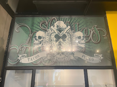 The image shows a glass window of an establishment named 'Ascalon', which features decorative skull graphics and text indicating that they serve tacos