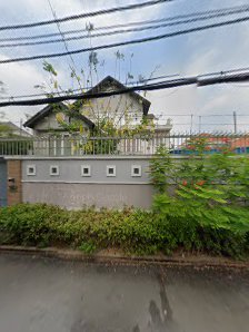 A residential house is visible behind a fence and greenery in Thao Dien, Saigon.