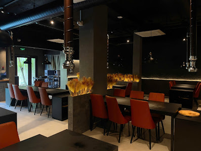 The image shows a modern interior of what appears to be a restaurant or bar in Thao Dien, Saigon. The space features dark tones with accents of orange