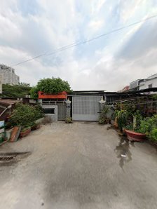 The image shows an exterior view of a residential area in Thao Dien, Saigon with various potted plants and greenery around the driveway leading to a g