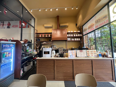 The image shows an interior view of a coffee shop or cafe located in Thao Dien, Saigon. The establishment has wooden countertops and cabinets with var