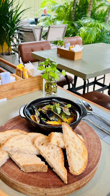 The image shows a dining area in Thao Dien, Saigon featuring a wooden table with food items and drinks on it.