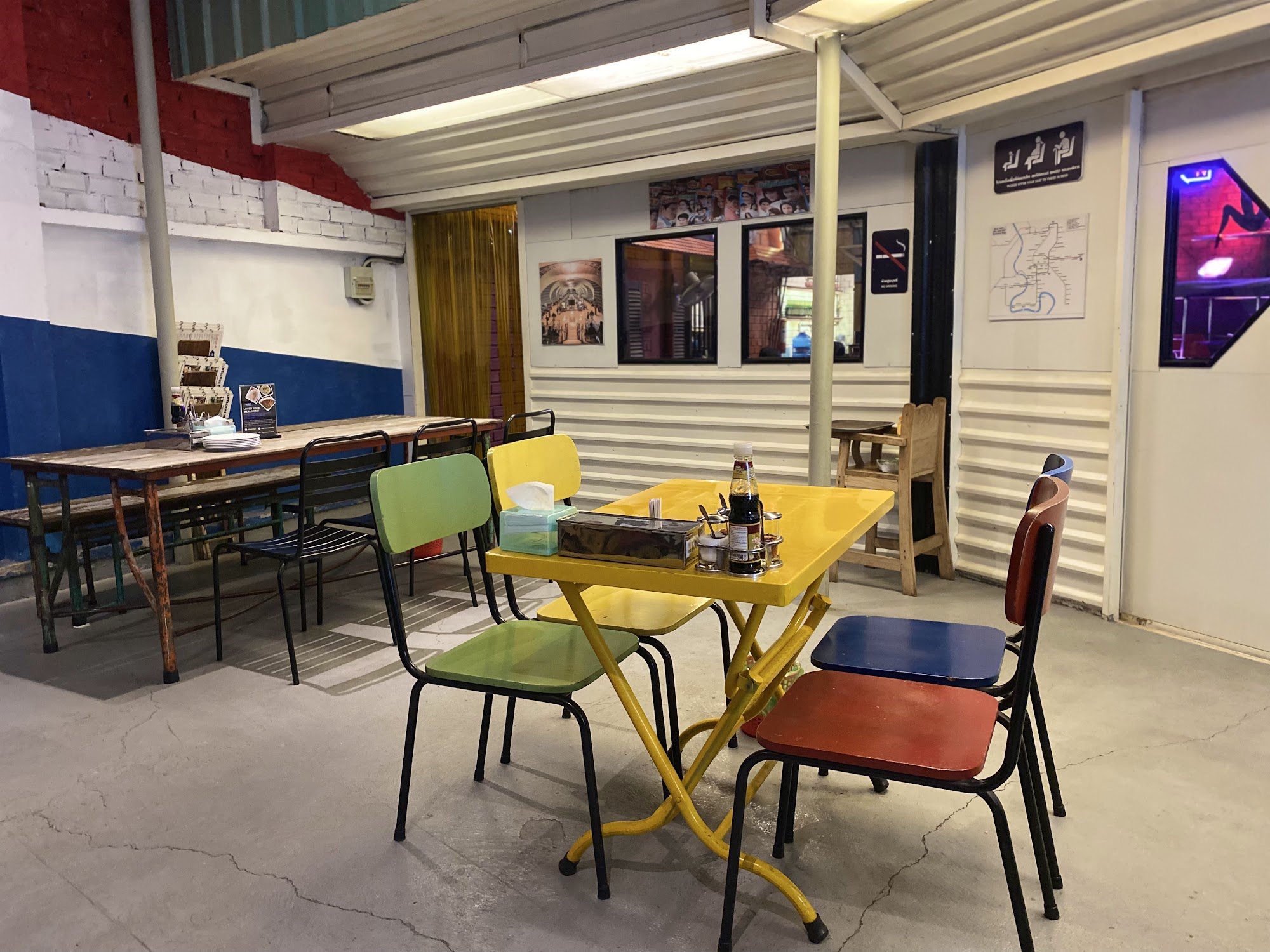 The image shows an interior space of a casual dining establishment in Thao Dien, Saigon. The area is painted with red and white stripes on the upper p