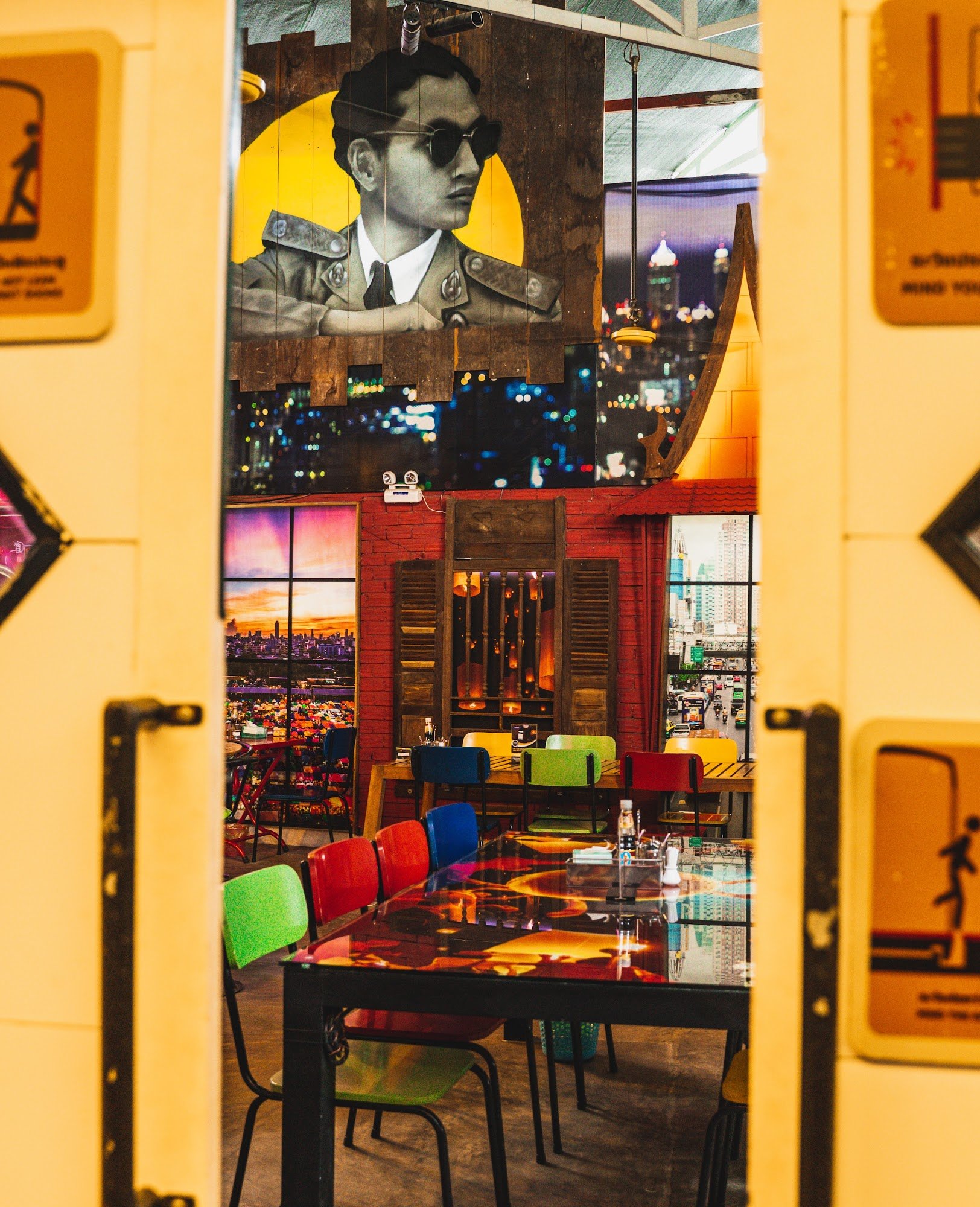The image shows an interior view of a restaurant or bar in Thao Dien, Saigon. The space features vibrant and eclectic decor with colorful chairs aroun