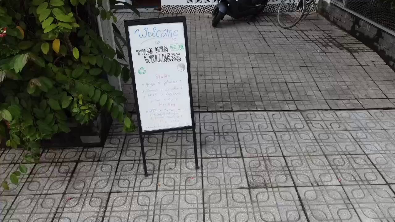 A signboard welcoming visitors to Thao Dien Eco Wellness Studio in Saigon.