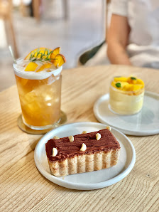 A slice of chocolate cake with nuts on top and a pastry topped with fruit slices