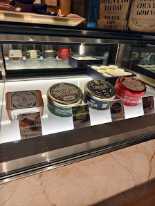 A display case in a cafe or restaurant showcasing various tins of tea and some packaged goods.