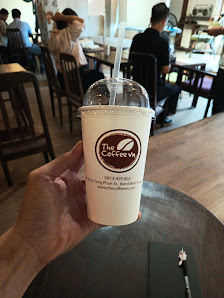 A hand is holding a cup of coffee from 'The Coffee Works' establishment in Thao Dien, Saigon.