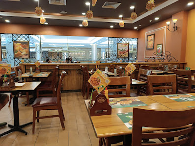 The image shows an interior view of a restaurant or cafe in Thao Dien, Saigon with wooden tables and chairs arranged throughout the space. The decor i