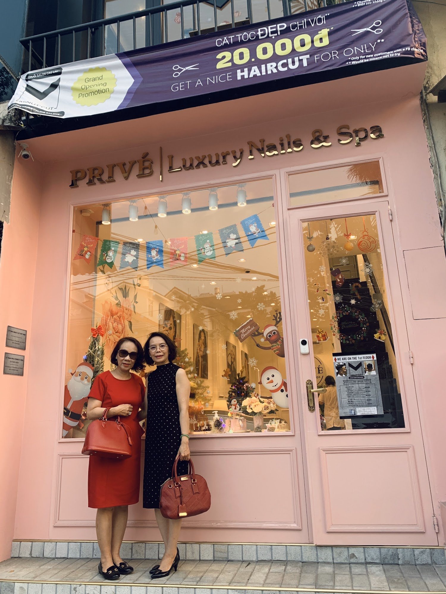 Exterior shot of PRIVÉ | Luxury Nails & Spa in Thao Dien, Saigon. Pink building with large windows displaying Christmas-themed decorations (snowmen, S