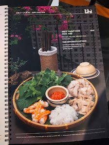 The image shows a menu from Thao Dien in Saigon featuring an appetizing dish with various ingredients such as shrimp, greens, rice, and mushrooms on a