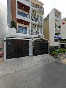 The image shows a residential building in Thao Dien, Saigon. It features multiple floors with balconies and large windows. The ground floor has a blac