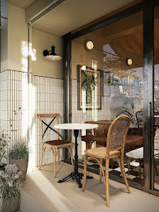 The image shows an outdoor seating area of a cafe or restaurant located in Thao Dien, Saigon. The setting includes two wooden chairs with woven seats