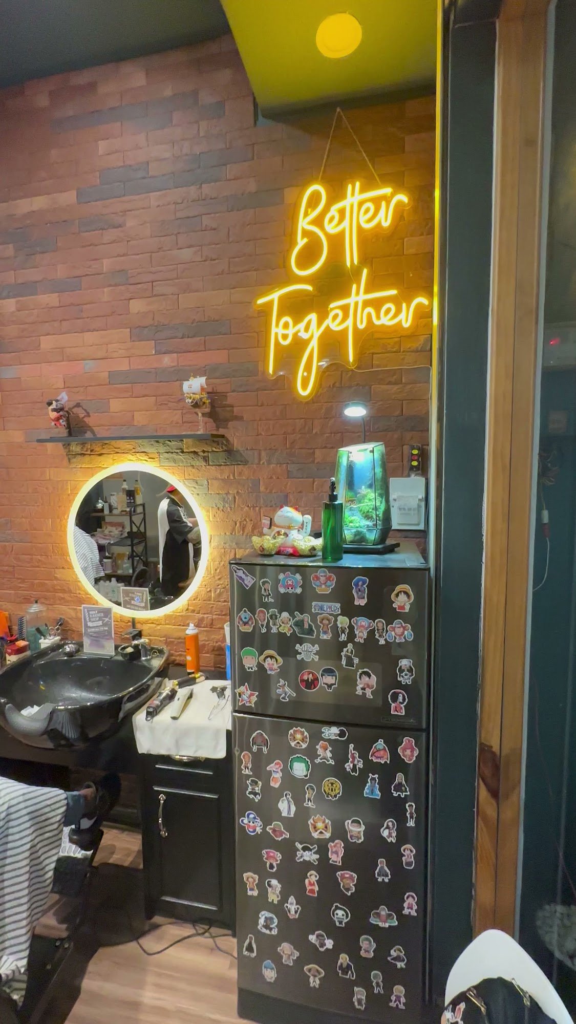 The image depicts the interior of a venue in Thao Dien, Saigon. Features include a brick wall backdrop with a glowing neon sign reading "Better Togeth