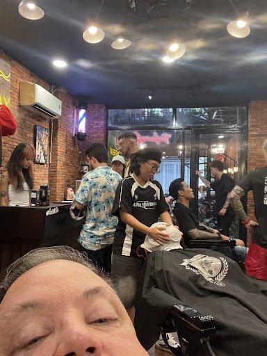 The image depicts an interior view of a barber shop or hair salon named 'Ain't No Crime'. The setting includes brick walls, modern lighting fixtures o