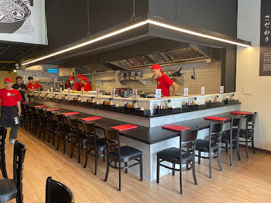 The image depicts the interior of a modern restaurant in Thao Dien, Saigon. It features a long counter with black stools that have red seats, position