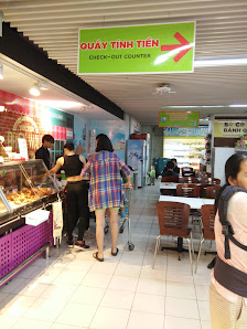 The image depicts the interior of a food venue in Thao Dien, Saigon. It features a counter with glass display cases (likely for baked goods or pastrie