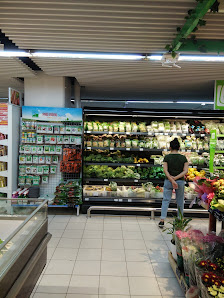 The image depicts the interior of a supermarket in Thao Dien, Saigon. It features a well-organized produce section with refrigerated shelves displayin