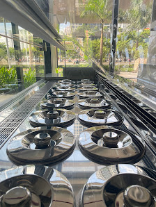 The image shows a close-up view of multiple black plates arranged in rows on what appears to be a buffet or display counter, likely inside a restauran