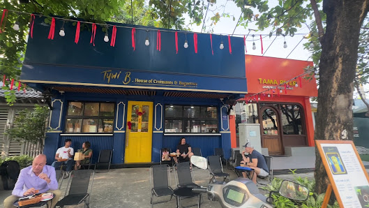The image shows an exterior view of a café named 'Tý Bi B.' which is part of the Thao Dien area in Saigon, Vietnam. The establishment has a distinctiv