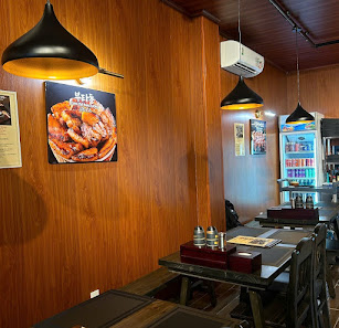 The image shows an interior view of a restaurant featuring wooden panel walls and modern lighting fixtures with hanging lamps. The decor includes fram