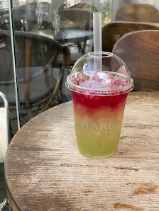 A colorful layered drink in a plastic cup with the brand 'VIARO' printed on it and a straw.