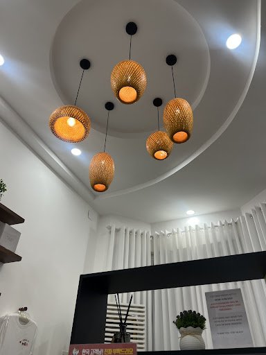 The image shows a modern interior space featuring unique hanging pendant lights with warm yellow shades and dark frames on the ceiling. The room has w