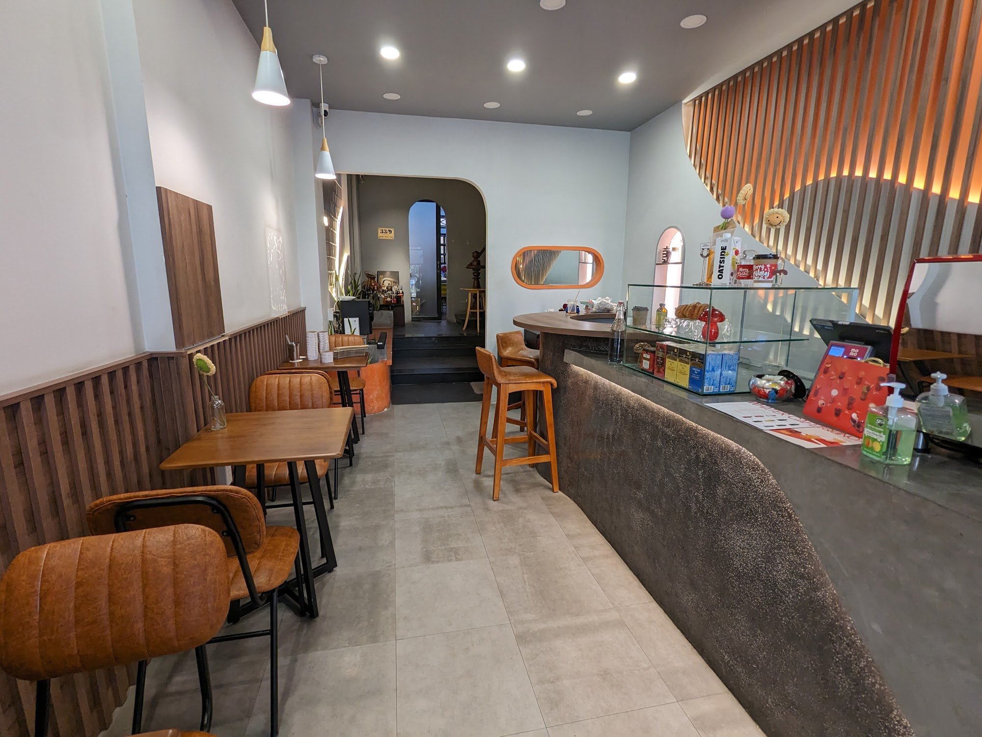 This image shows an interior view of a modern cafe or restaurant in Thao Dien, Saigon. The space features contemporary design elements such as wooden