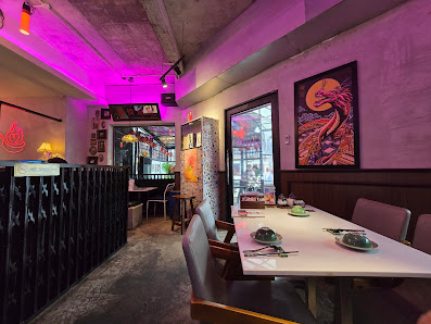 The image shows an indoor dining area of a restaurant or bar in Thao Dien, Saigon. The space has pink ambient lighting and features modern decor with 
