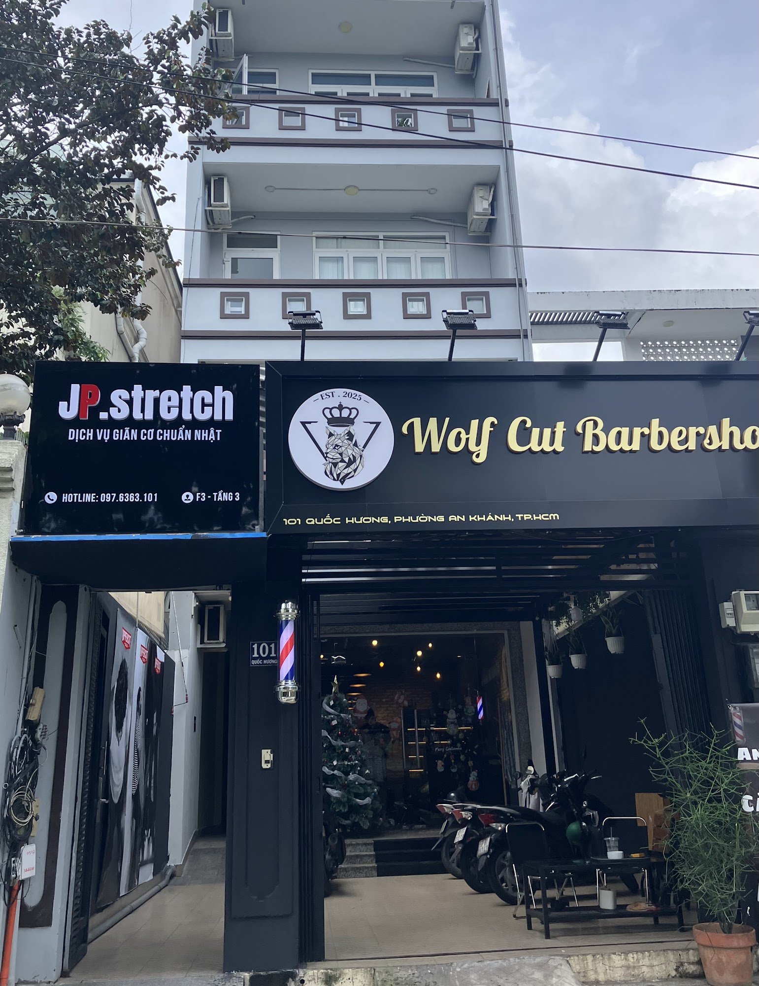 The image shows a storefront of two businesses located on the ground floor of an urban building in Thao Dien, Saigon.