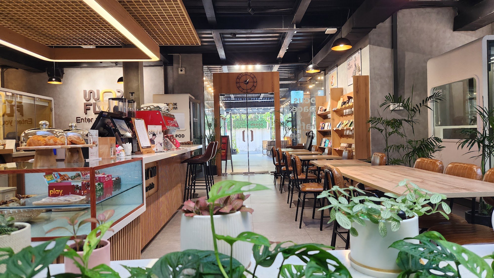 The image shows an interior view of a modern cafe or coffee shop named 'Word Floor'. The space is well-lit with natural light coming through the large