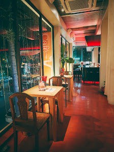 The image shows an indoor setting of a cafe or restaurant at night time. The interior has warm lighting with red and yellow hues, creating a cozy atmo