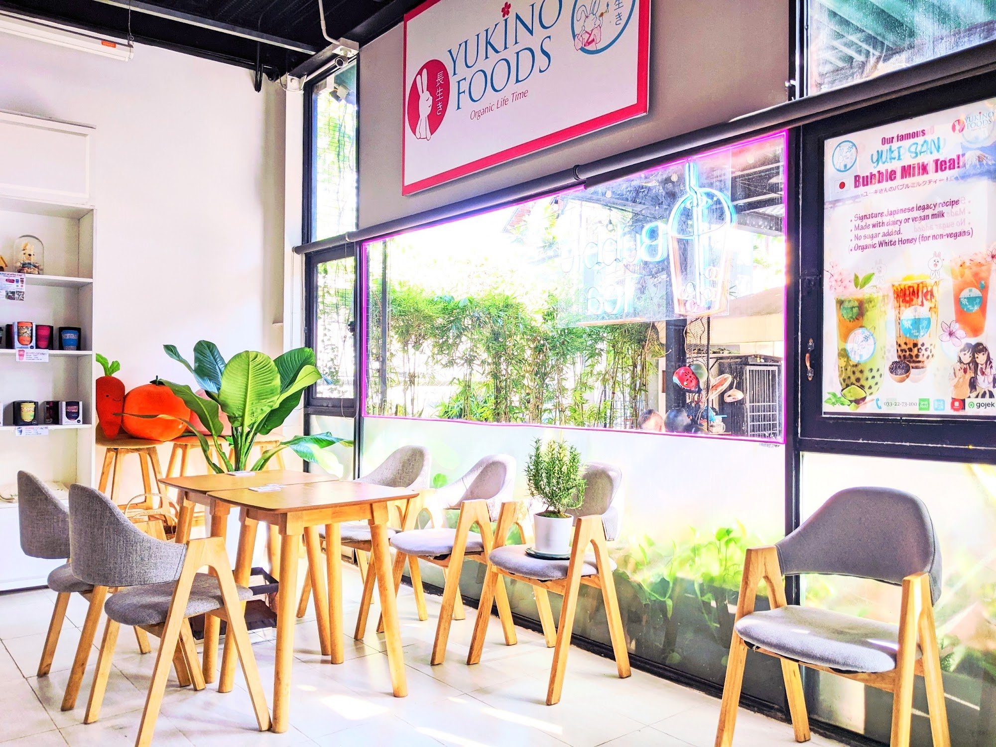 The image shows an interior view of a cafe named Yukino Foods in Thao Dien, Saigon. The space is well-lit with natural light coming through the large