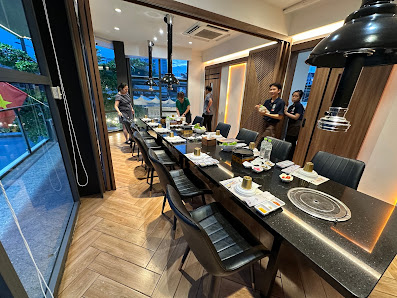 The image shows a modern dining area in an upscale restaurant or home setting at night time with dim lighting and contemporary decor.